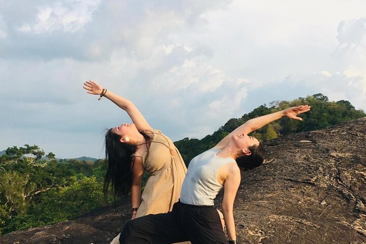 zwei Menschen stehen mit erhobenen Armen auf einem Felsen