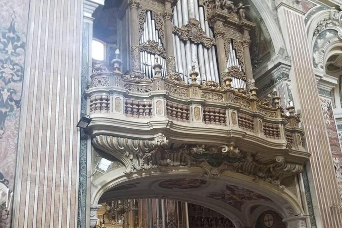 an ornate organ in a church with a large doorway