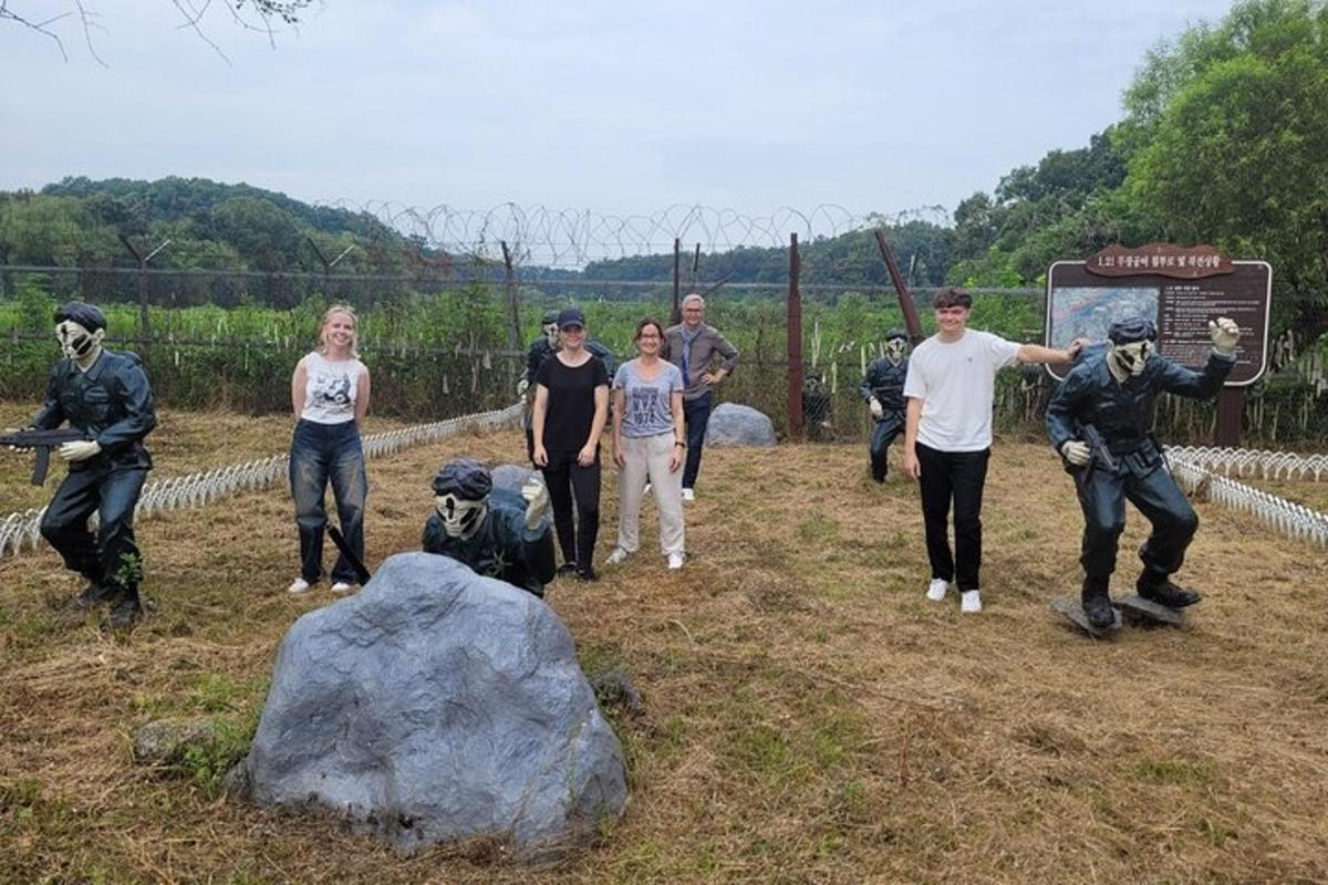 un grup de persones dretes davant d'una roca