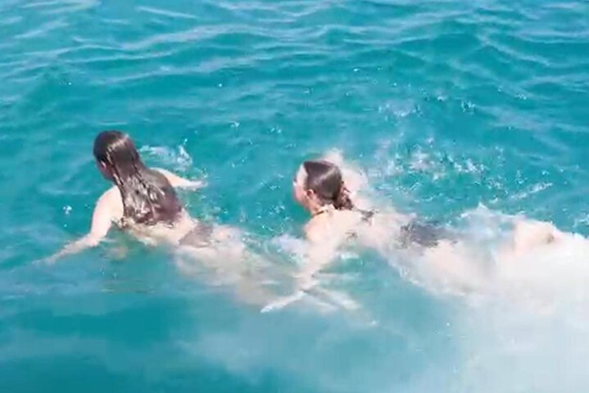 two girls are swimming in the water