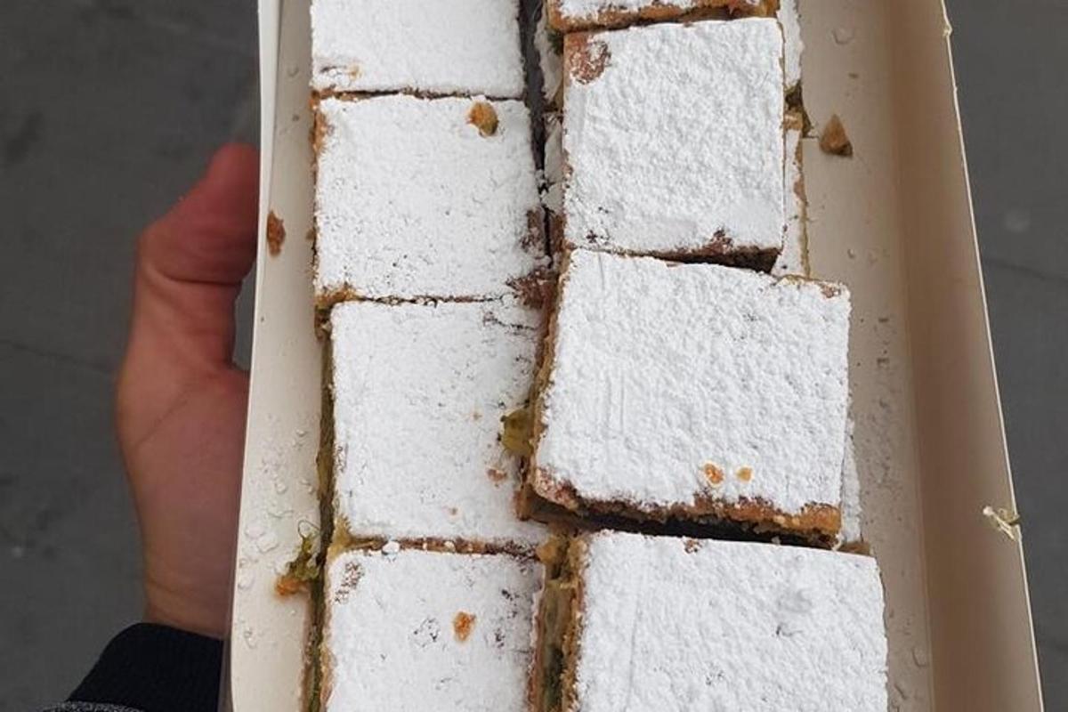 a person holding a white cake in a box