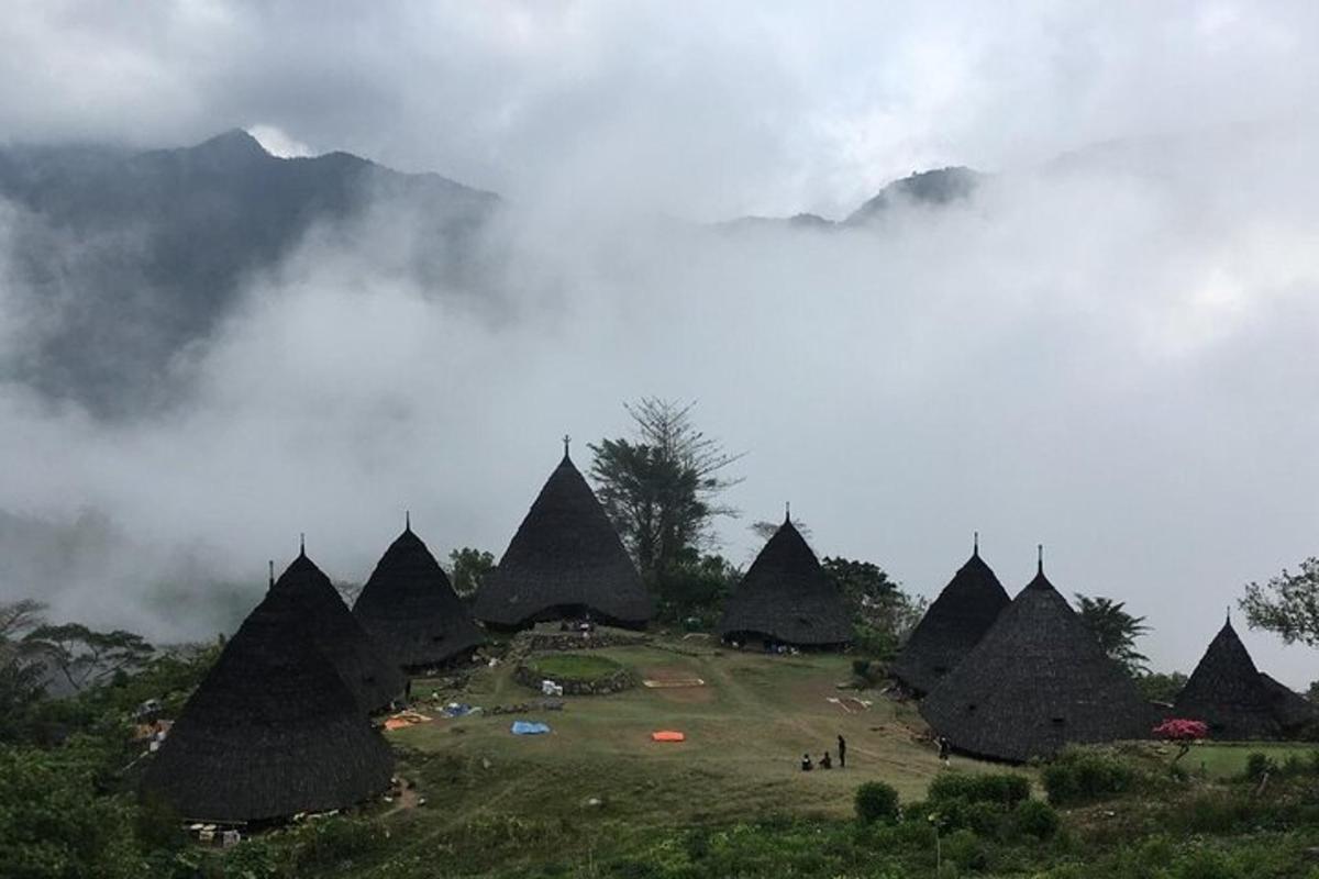 eine Gruppe von Zelten auf einem Hügel mit Wolken am Himmel