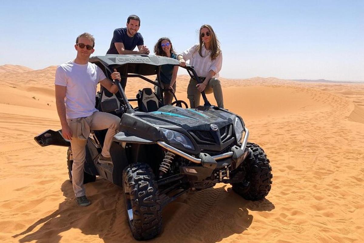 um grupo de pessoas sentadas em um quadriciclo no deserto