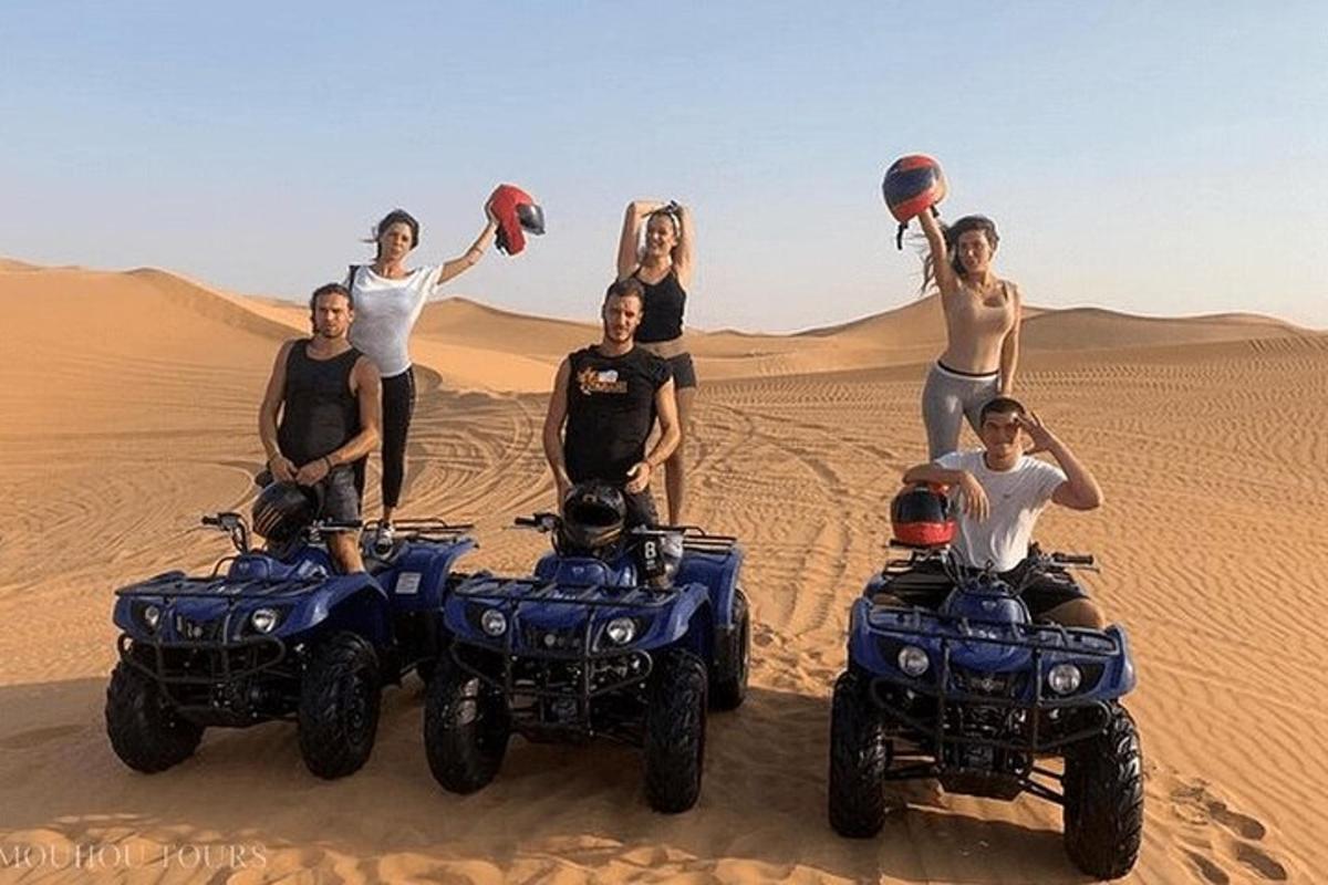 un gruppo di persone in piedi nel deserto con i quad