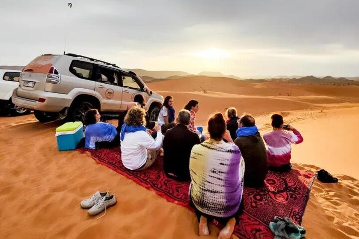 a group of people sitting on a rug in the desert