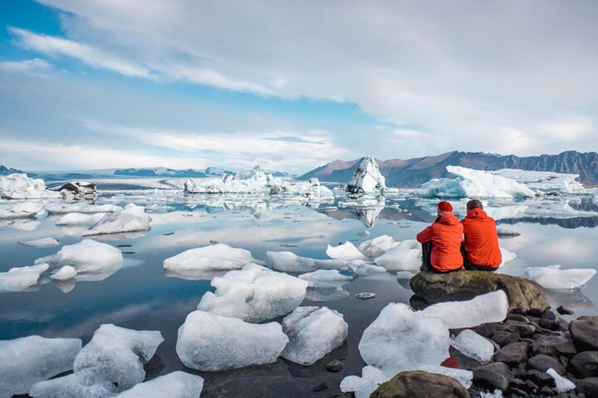 due persone sedute su una roccia in uno specchio d'acqua