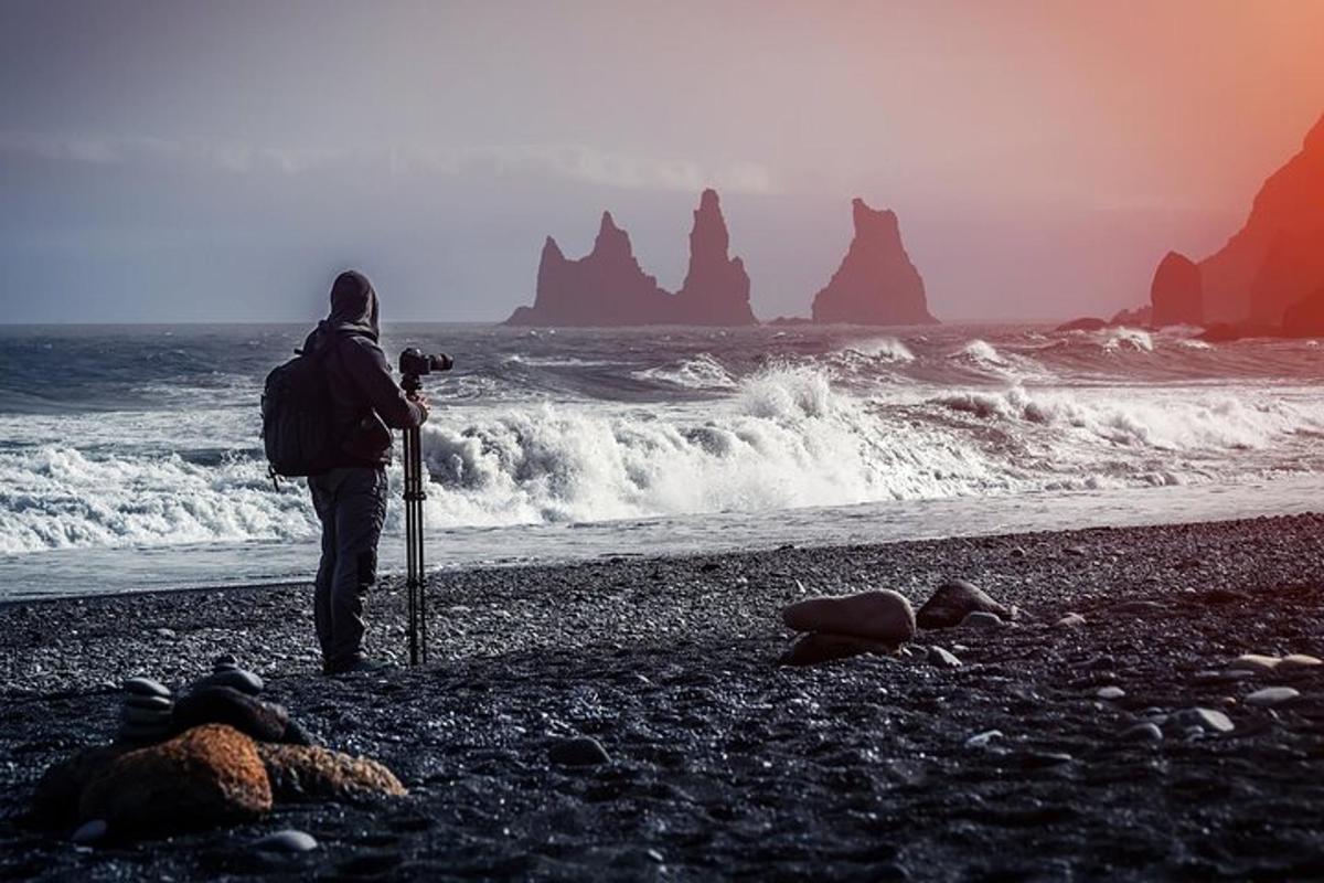 una persona in piedi su una spiaggia che scatta una foto dell'oceano