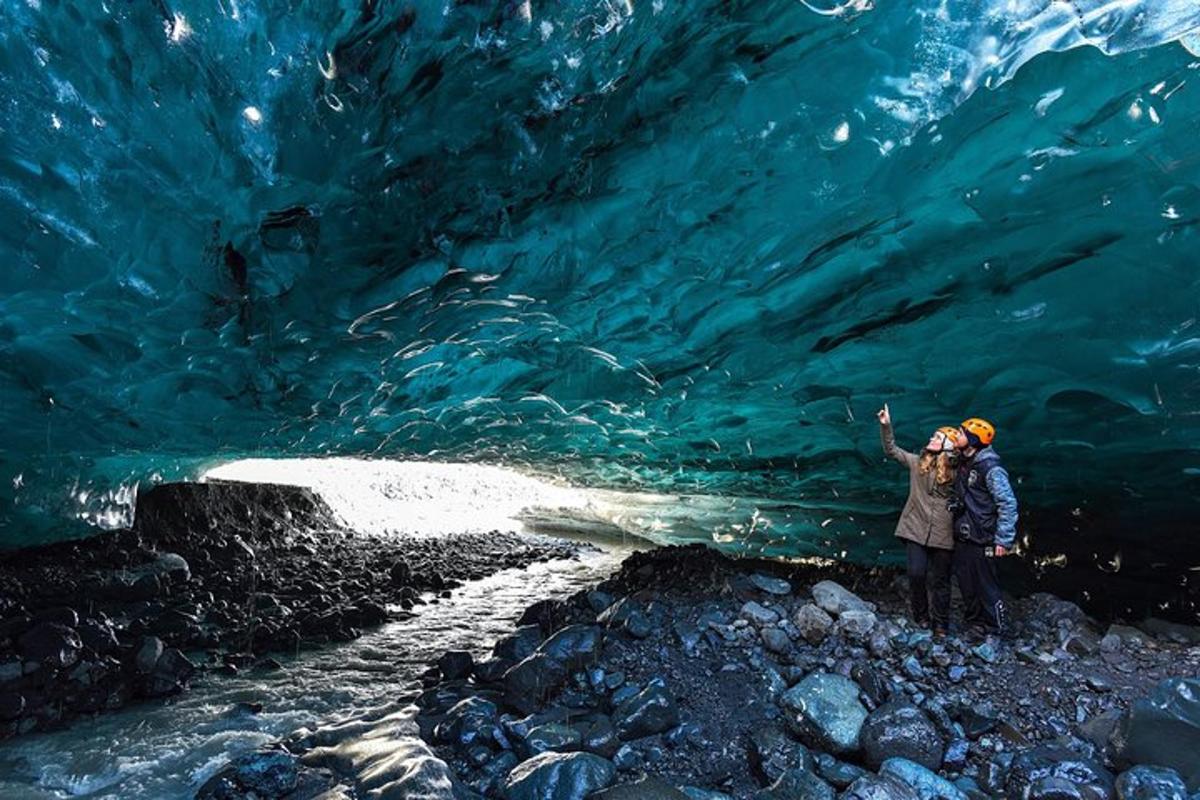 due persone in piedi davanti a una grotta di ghiaccio