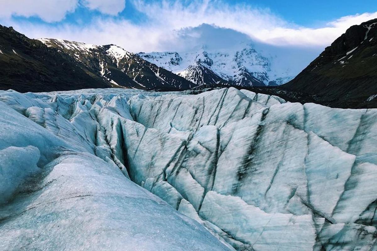un ghiacciaio con montagne innevate sullo sfondo