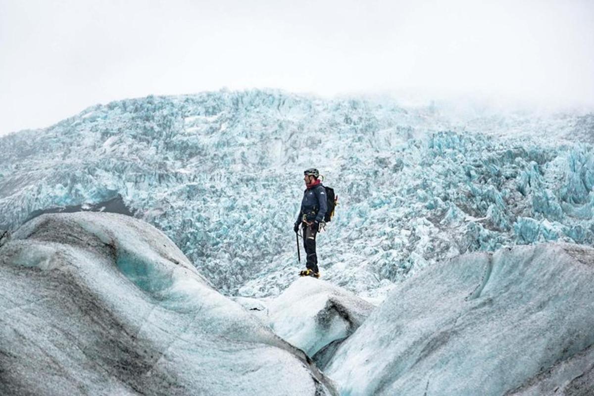 un uomo è in piedi sulla cima di un ghiacciaio