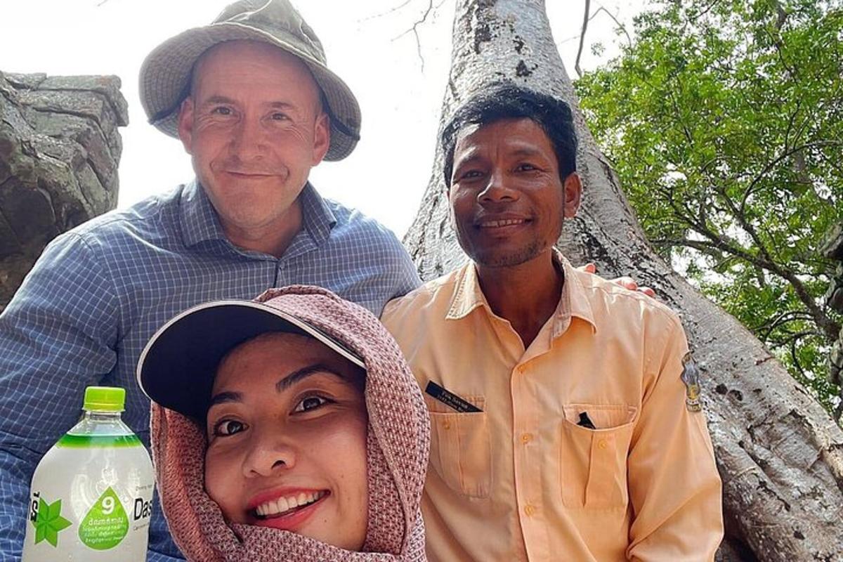 dua lelaki dan seorang wanita berdiri di sebelah pokok