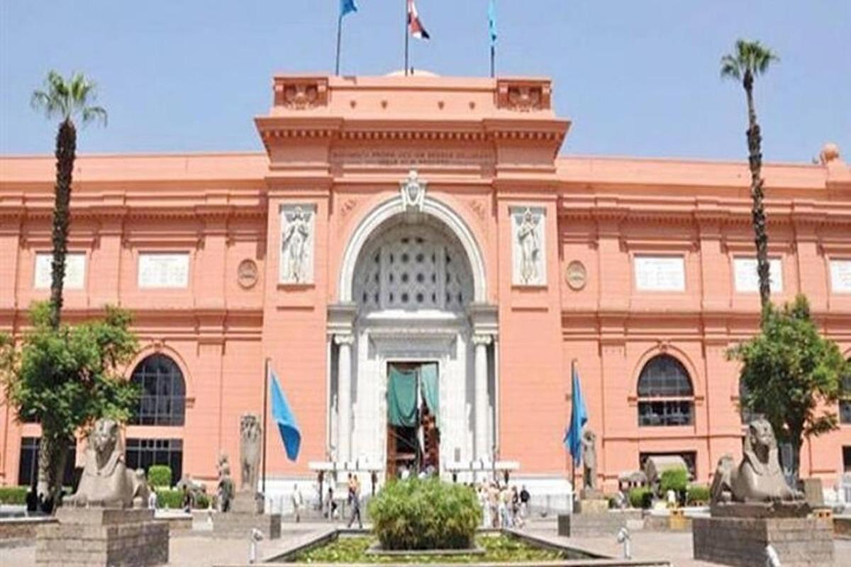 un grand bâtiment avec deux drapeaux devant lui