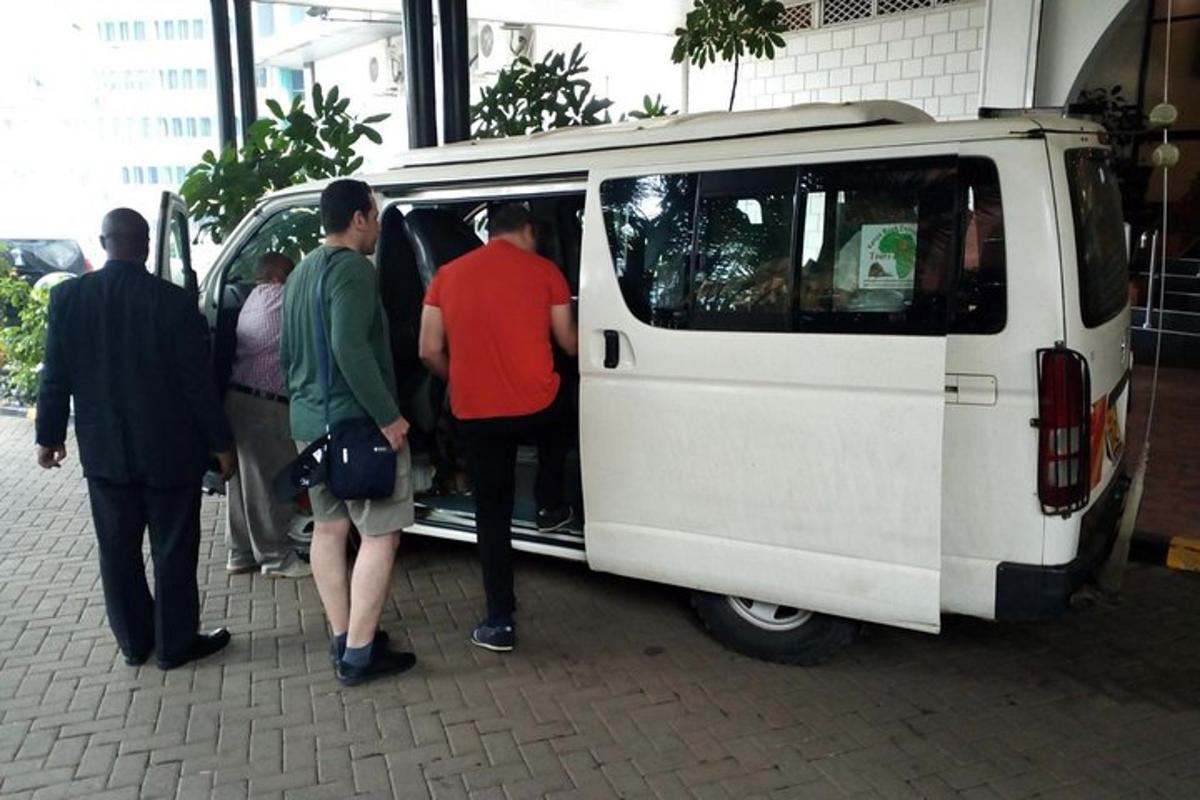 a group of people standing outside of a white van
