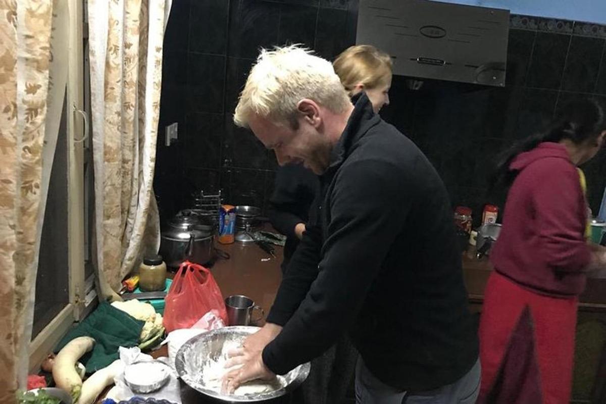 muž stojící v kuchyni a připravující jídlo na pánvi