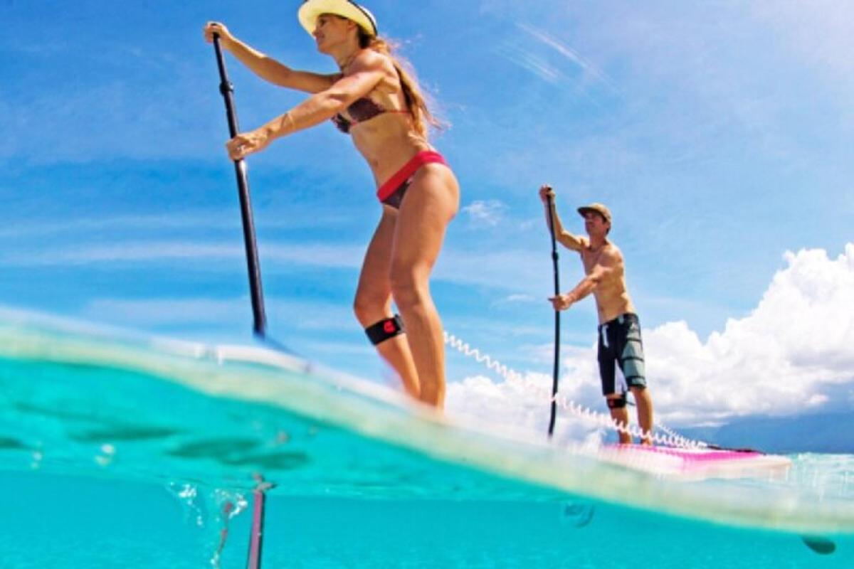een man en een vrouw op een paddleboard in het water