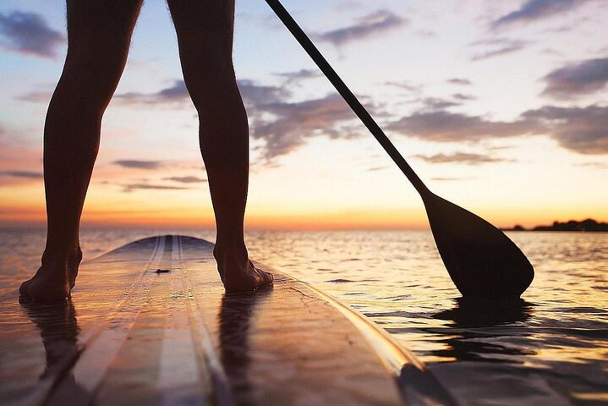 člověk stojí na paddleboardu ve vodě