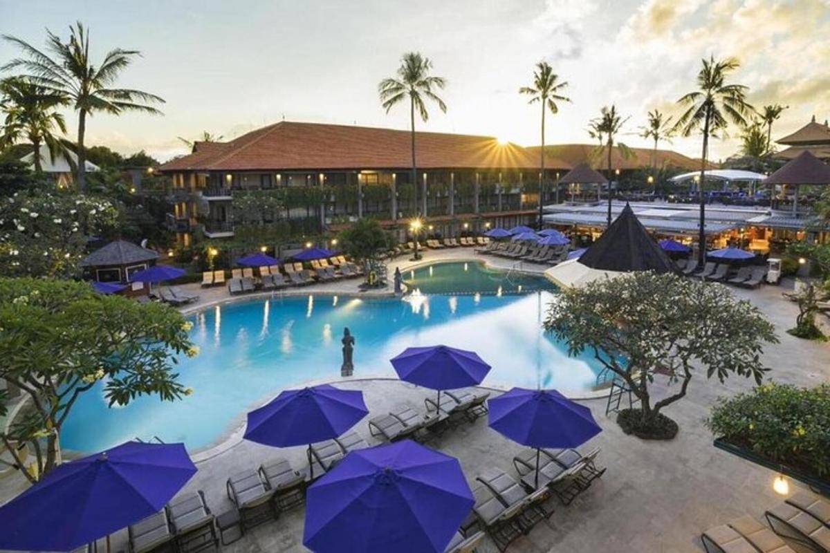 an overhead view of a large pool with blue umbrellas