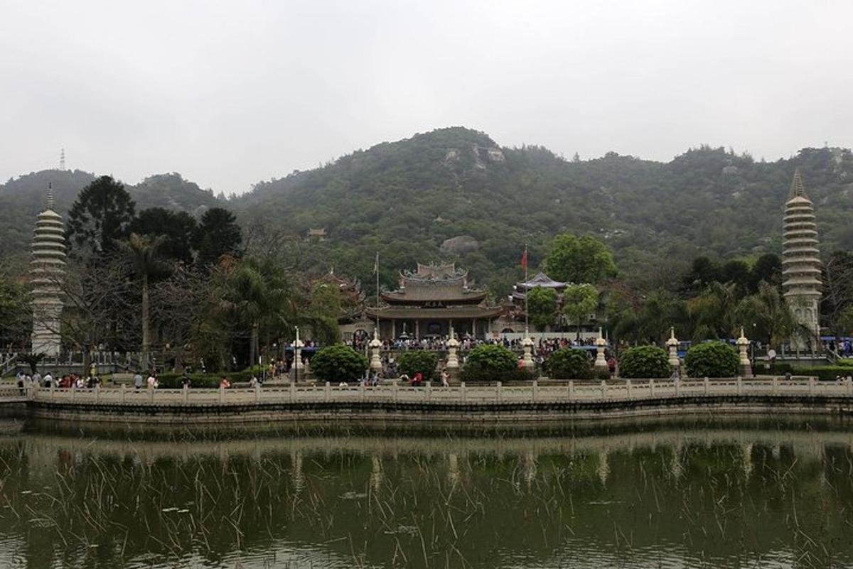 a bridge over a lake with a building in the background