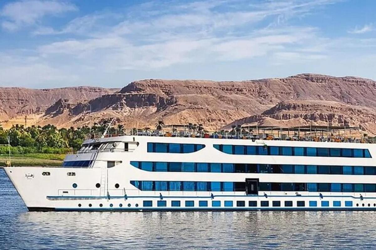 una nave da crociera in acqua con le montagne sullo sfondo