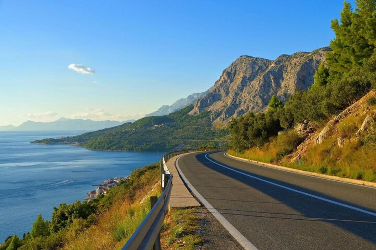 un camino en la ladera de una montaña al lado del agua