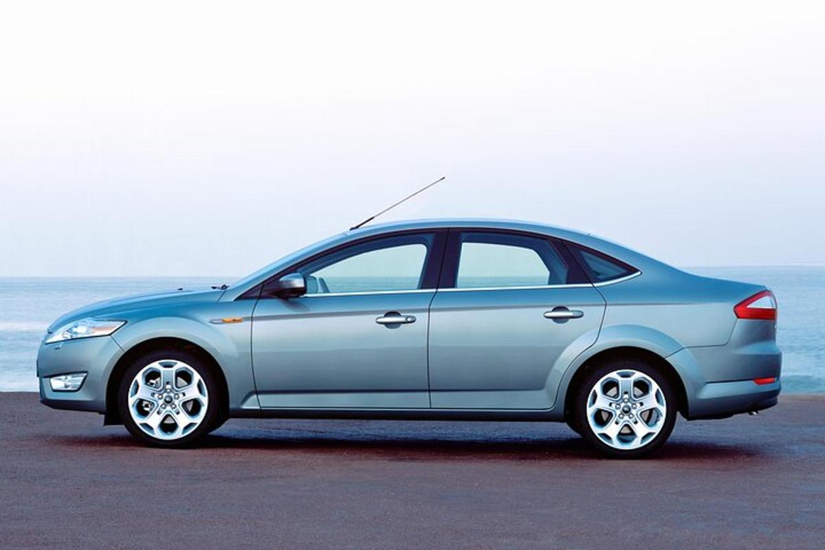 modré auto zaparkované před oceánem