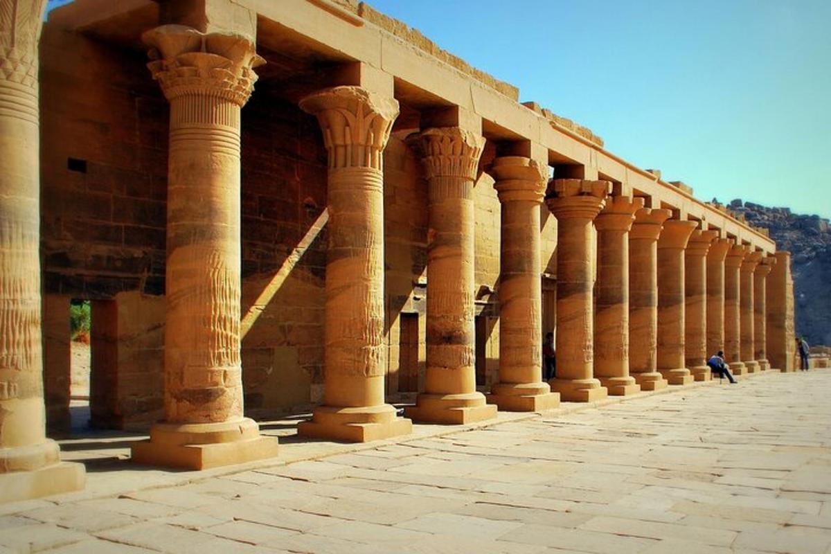 una filera de columnes d'un edifici amb una persona dempeus al davant