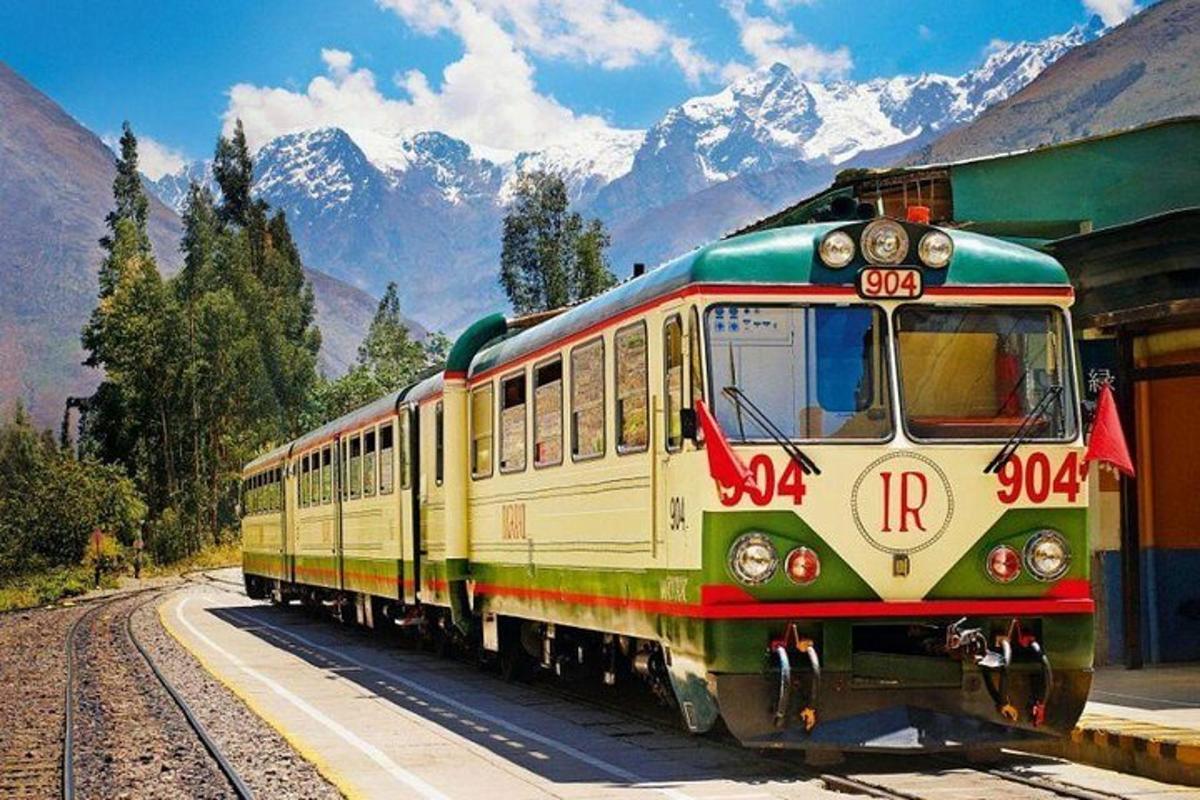 un train sur les rails avec des montagnes en arrière-plan