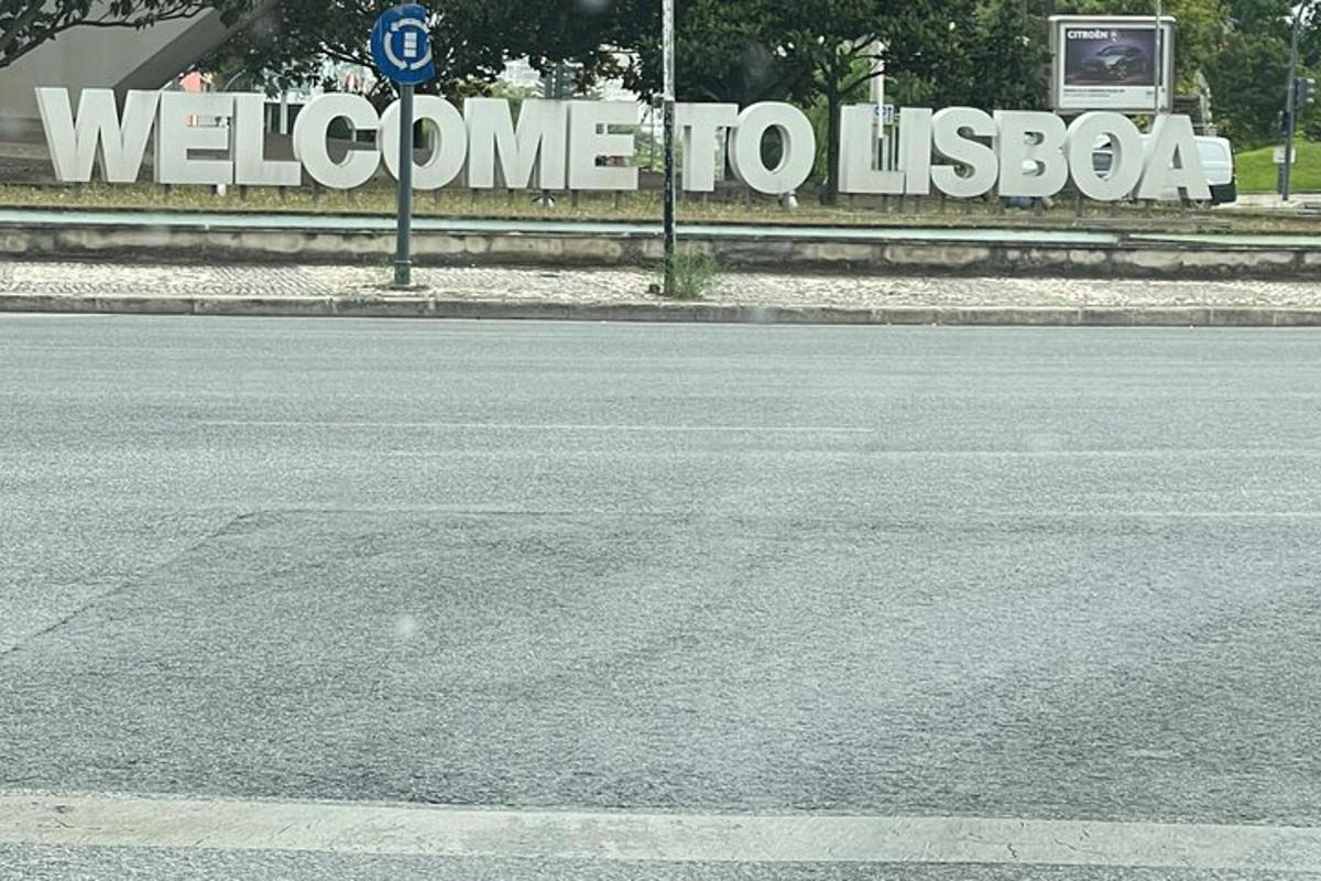uma rua vazia com uma placa de boas-vindas a Lisboa