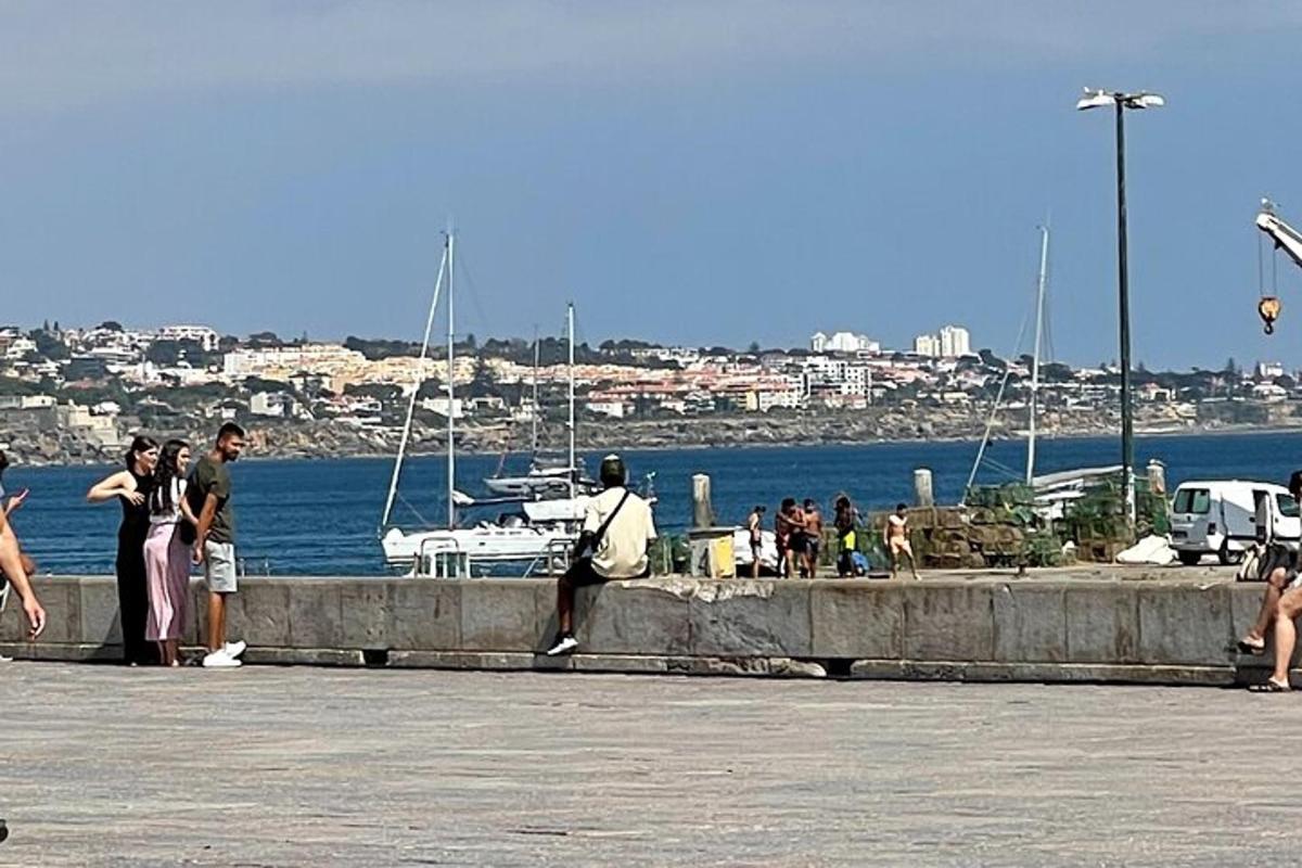 um grupo de pessoas em pé em uma doca perto da água