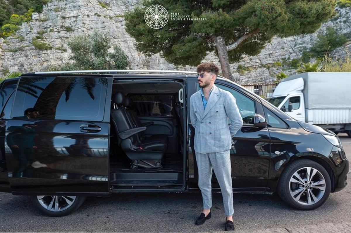 vyras su kostiumu, stovintis šalia mikroautobuso
