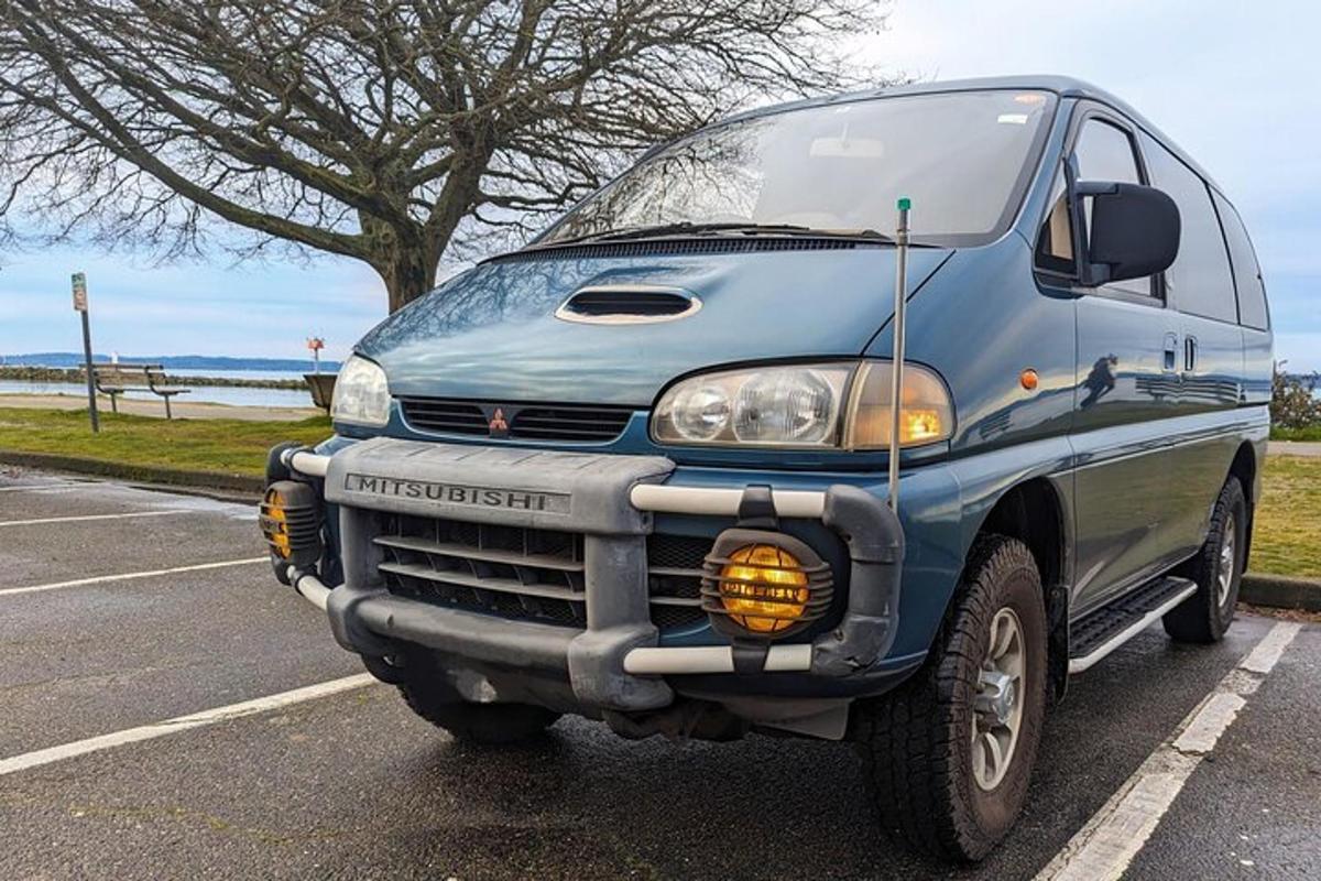 otoparkta park edilmiş mavi bir minibüs