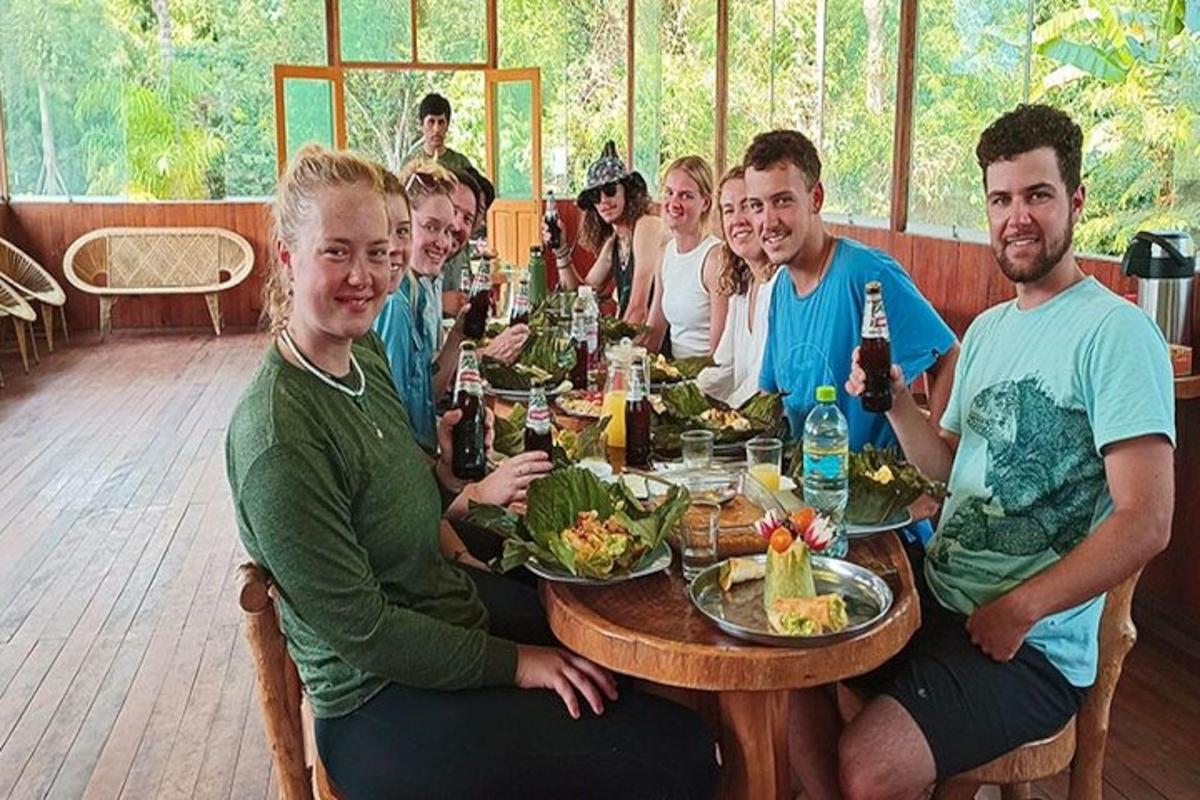 skupina lidí sedících kolem stolu s jídlem