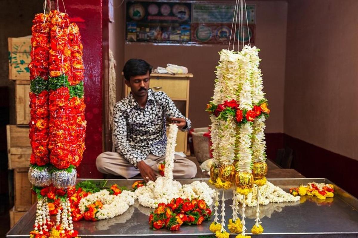 um homem sentado em frente a uma exposição de flores
