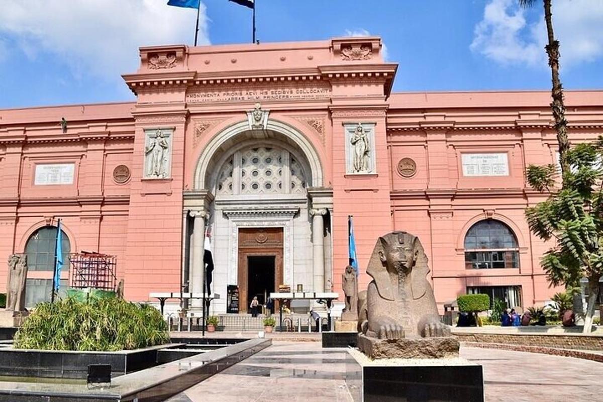 un edificio rosa con una statua di fronte