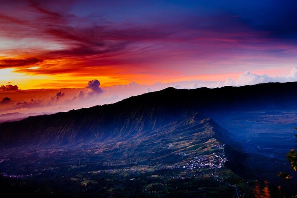 un tramonto su una catena montuosa con una città