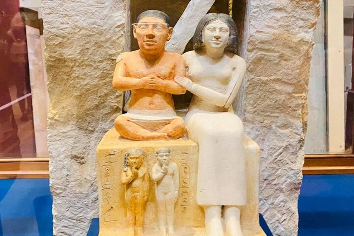 una statua di un uomo e una donna seduti su una scatola