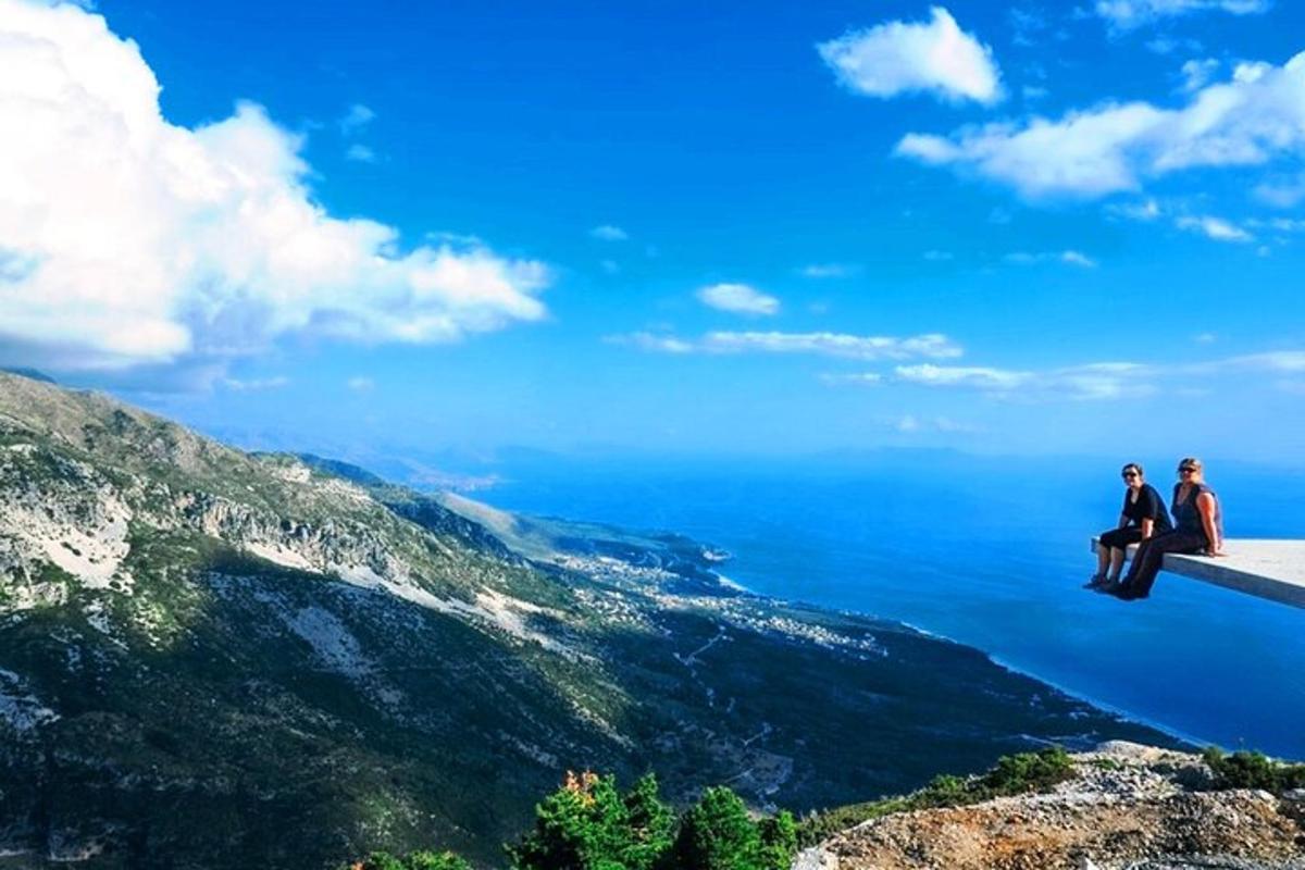 dues persones assegudes en una cornisa amb vistes a l'oceà