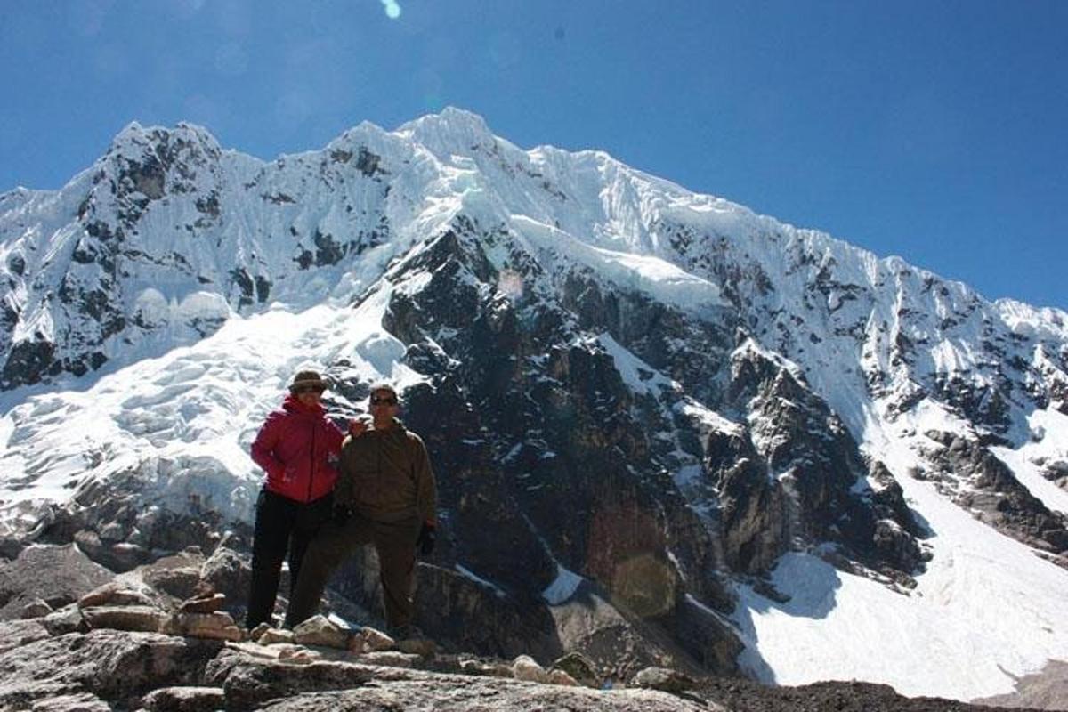 duas pessoas em pé no topo de uma montanha coberta de neve