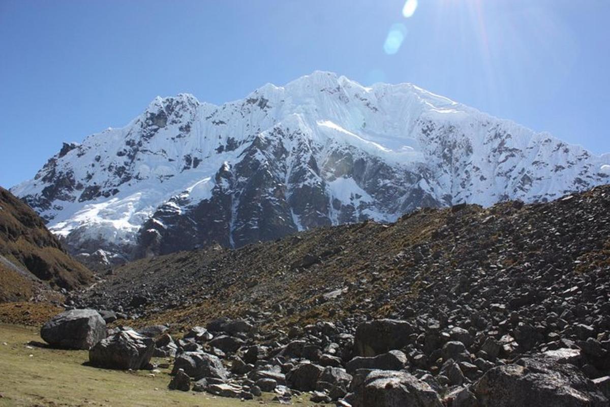 uma montanha coberta de neve em frente a uma montanha rochosa