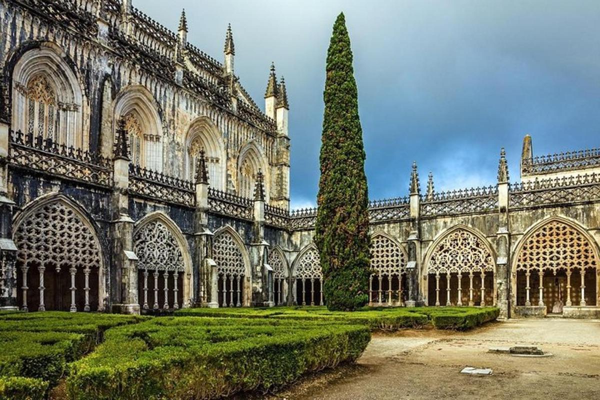 Un gran edificio con un árbol delante.