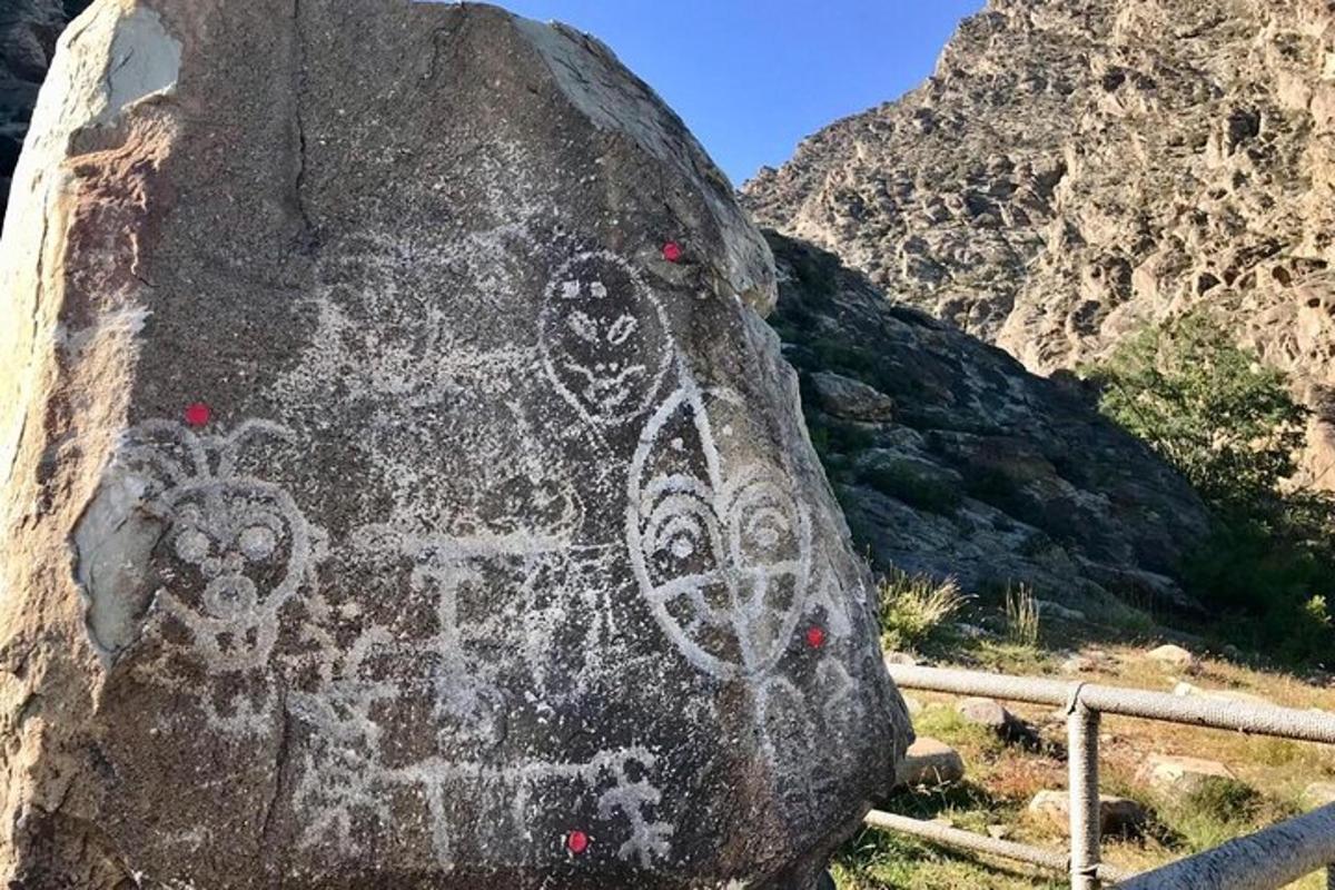 a rock with graffiti on it on a mountain