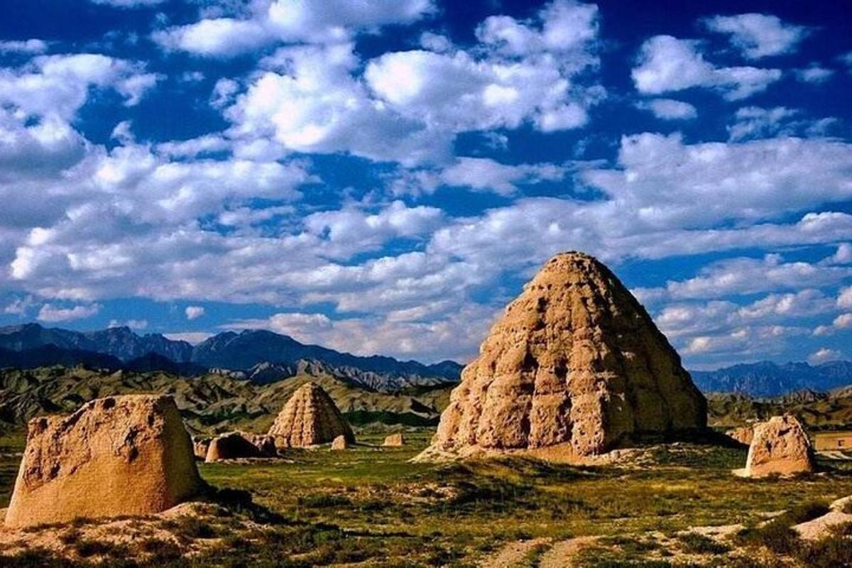 a group of stone domes in a grassy field