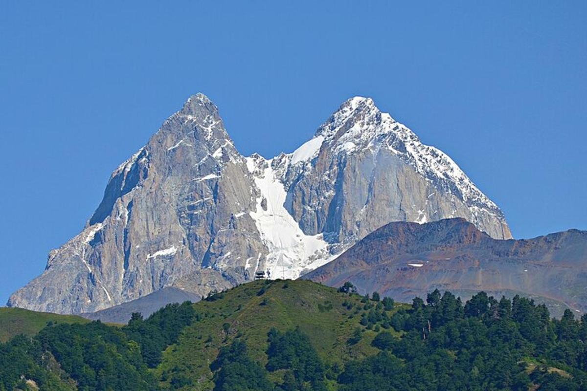 gunung berbatu besar dengan pokok di hadapannya