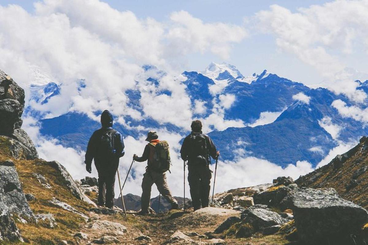 un grup de trei persoane care stau pe vârful unui munte