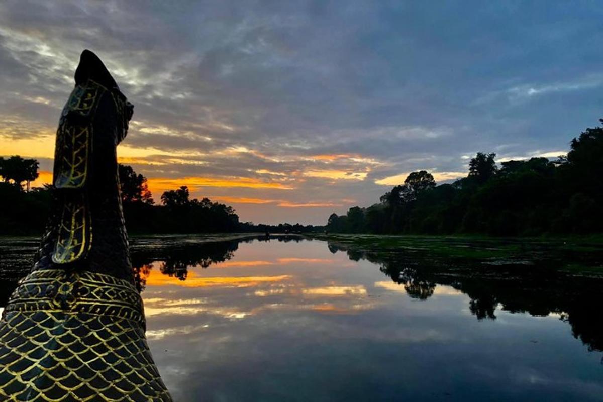 en båd på en flod med en solnedgang i baggrunden