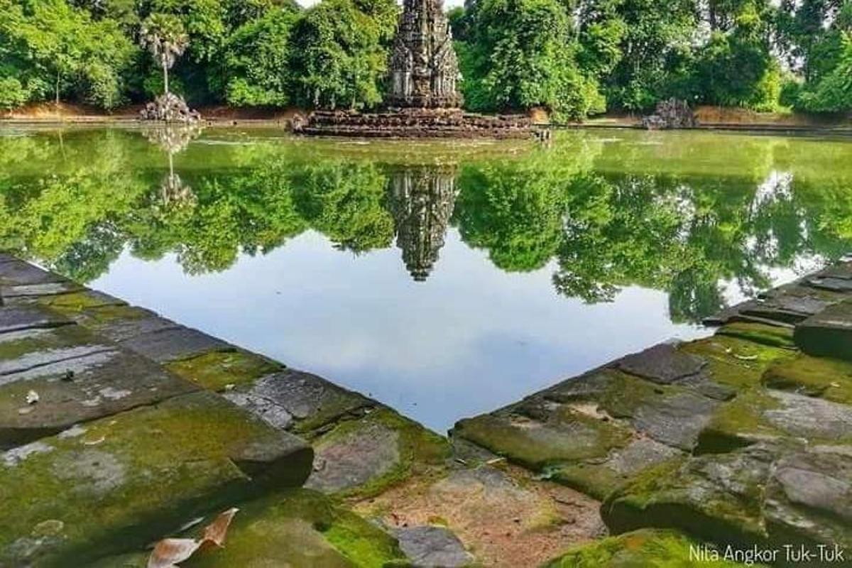 un reflex d'una estàtua en un estany d'un parc