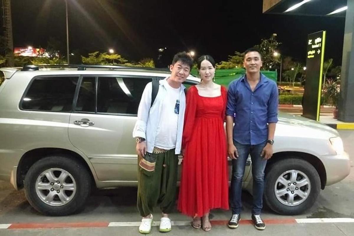 กลุ่มคนยืนอยู่หน้ารถยนต์