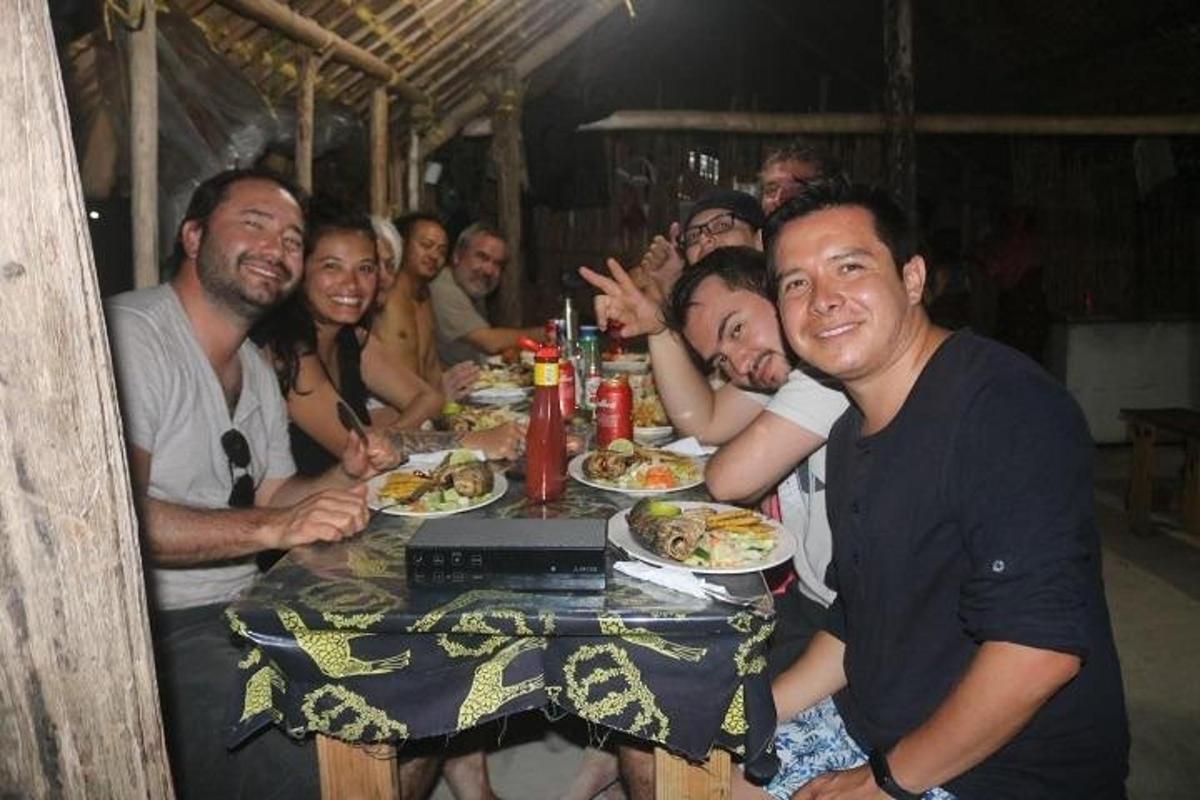 a group of people sitting around a table eating food