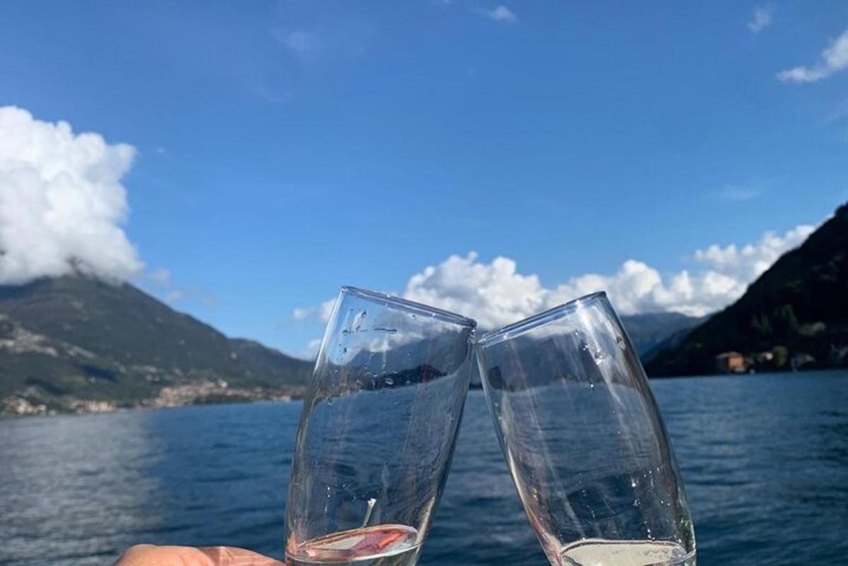 two glasses of wine sitting next to a body of water