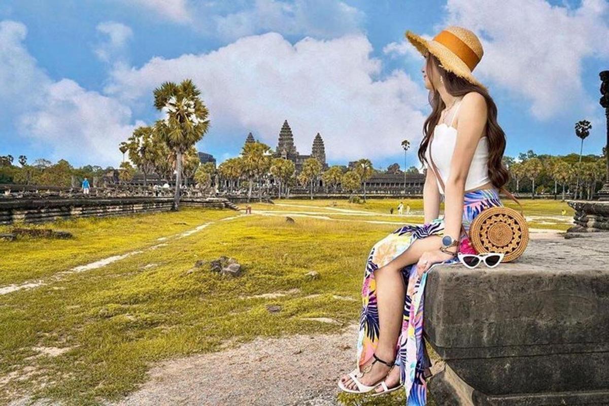 a woman sitting on a wall looking at a temple